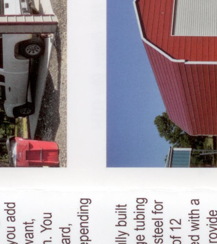 Red metal gambrel-roof barn style building with white roll-up door